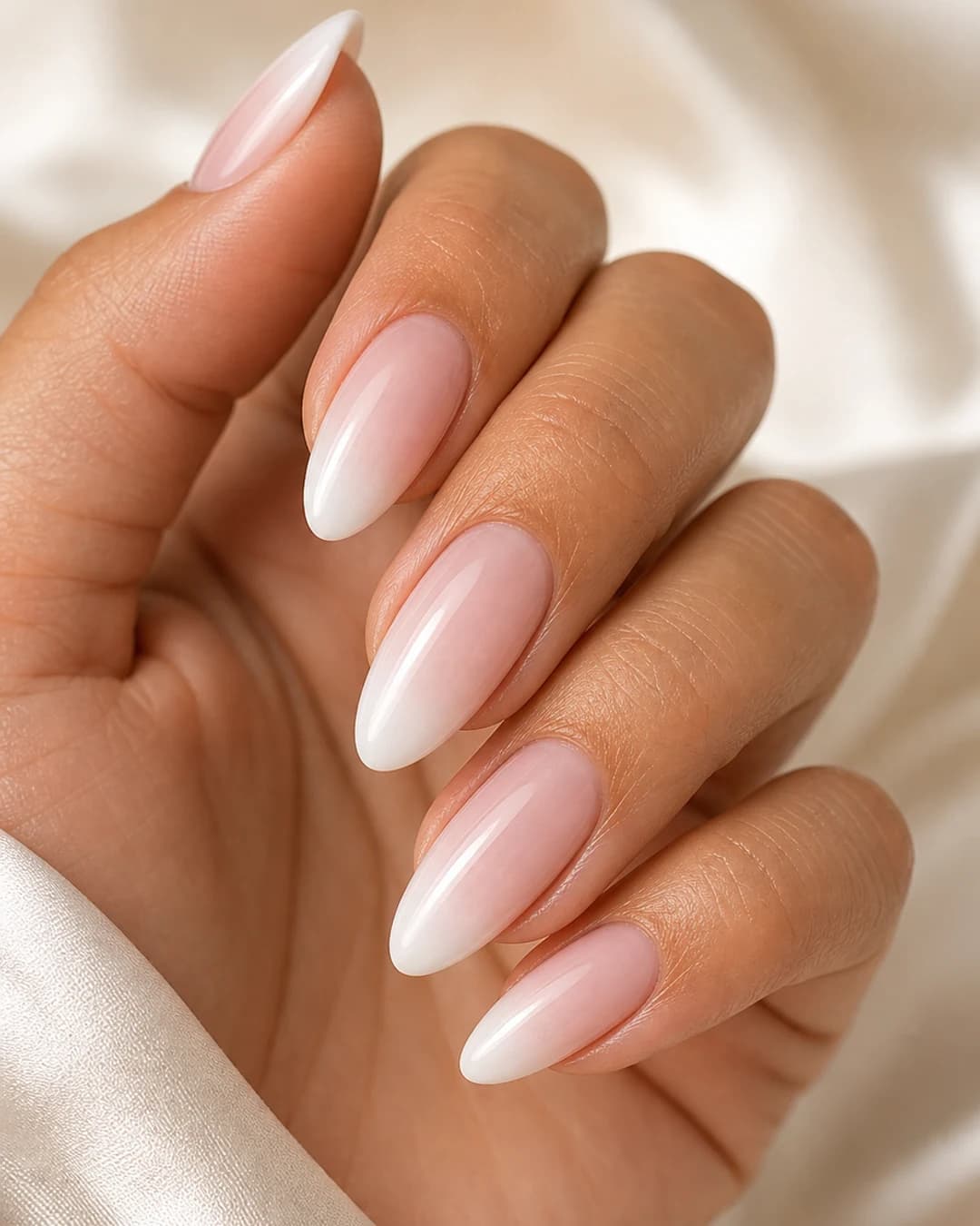 Uñas almendradas con degradado baby boomer del nude rosado al blanco